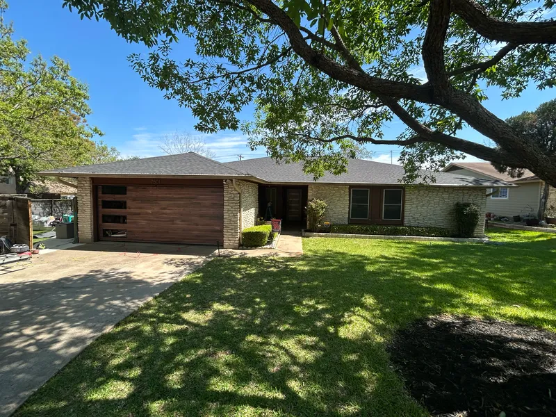 Austin home exterior painted black with a modern wood front door by V&S Painting